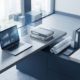 Modern kantoor met laptop die ERP-grafieken toont, architecturale tekeningen en rekenmachine op minimalistische werkplek